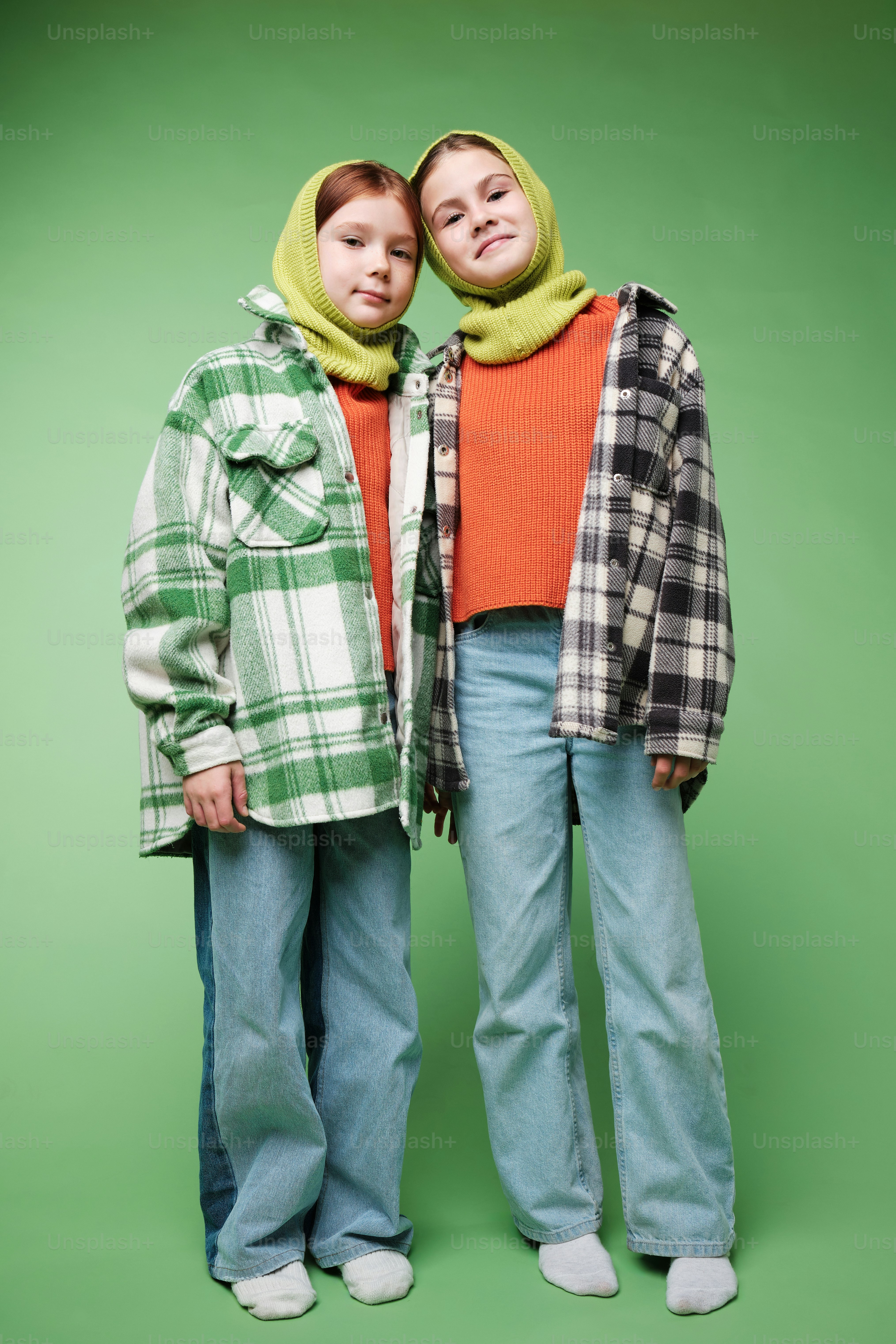 A two girls in autumn clothes on studio background in warm color scheme