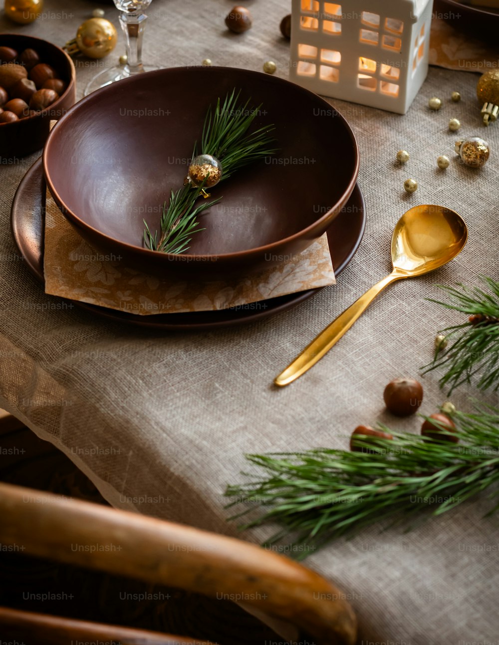 a table set with a brown plate and gold spoons