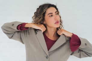 a woman wearing a blazer and a red shirt