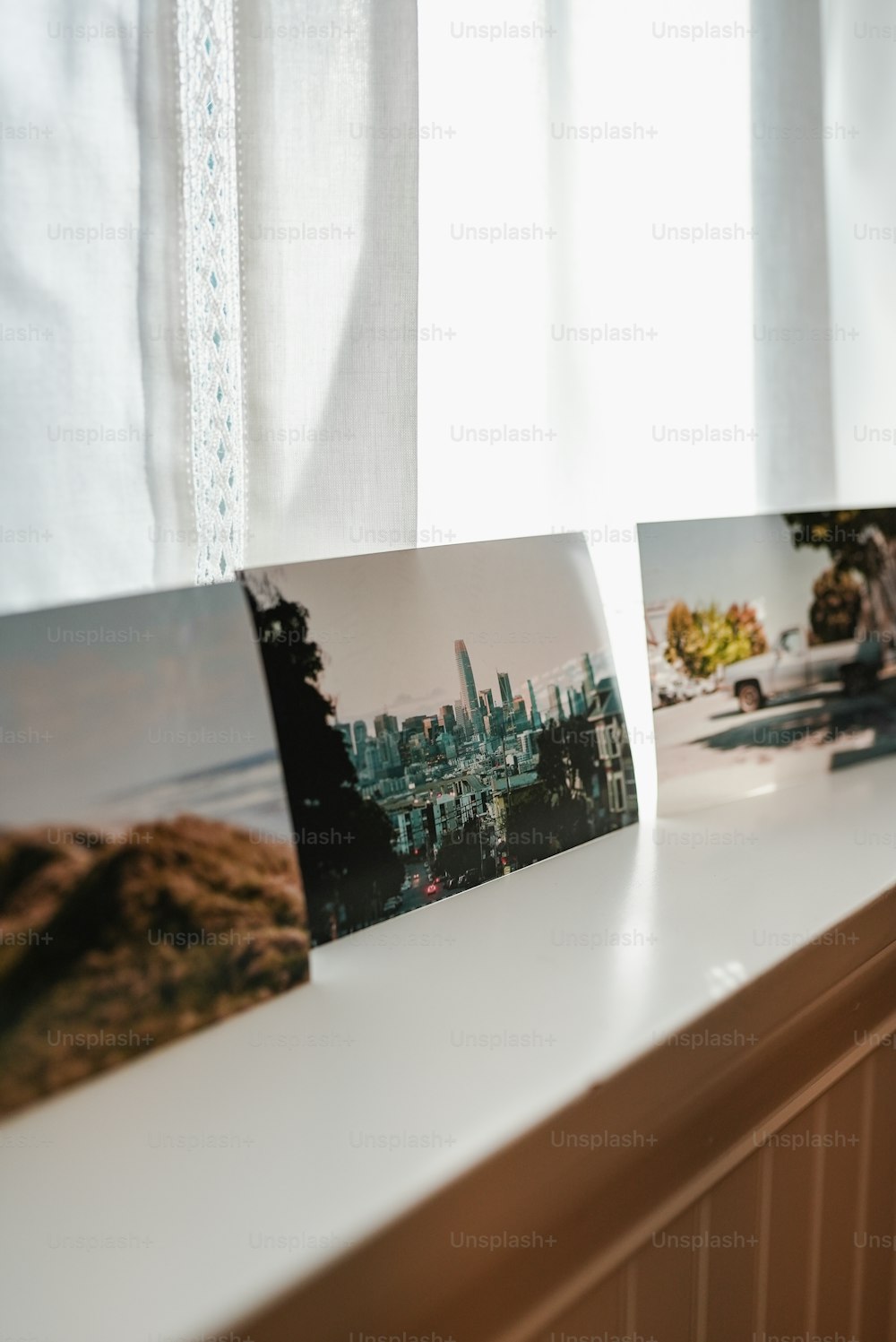 a window sill with three pictures hanging on it