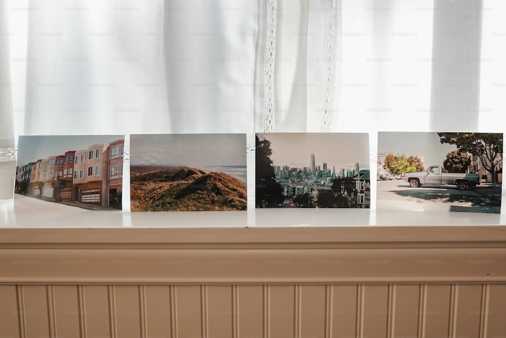 a window sill with four pictures hanging on it