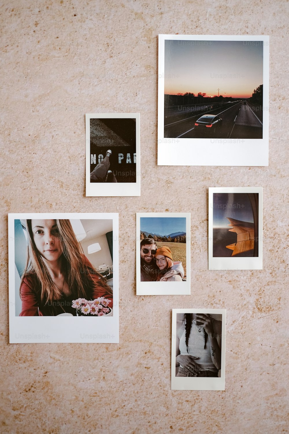 ein Haufen Polaroid-Bilder, die an einer Wand hängen