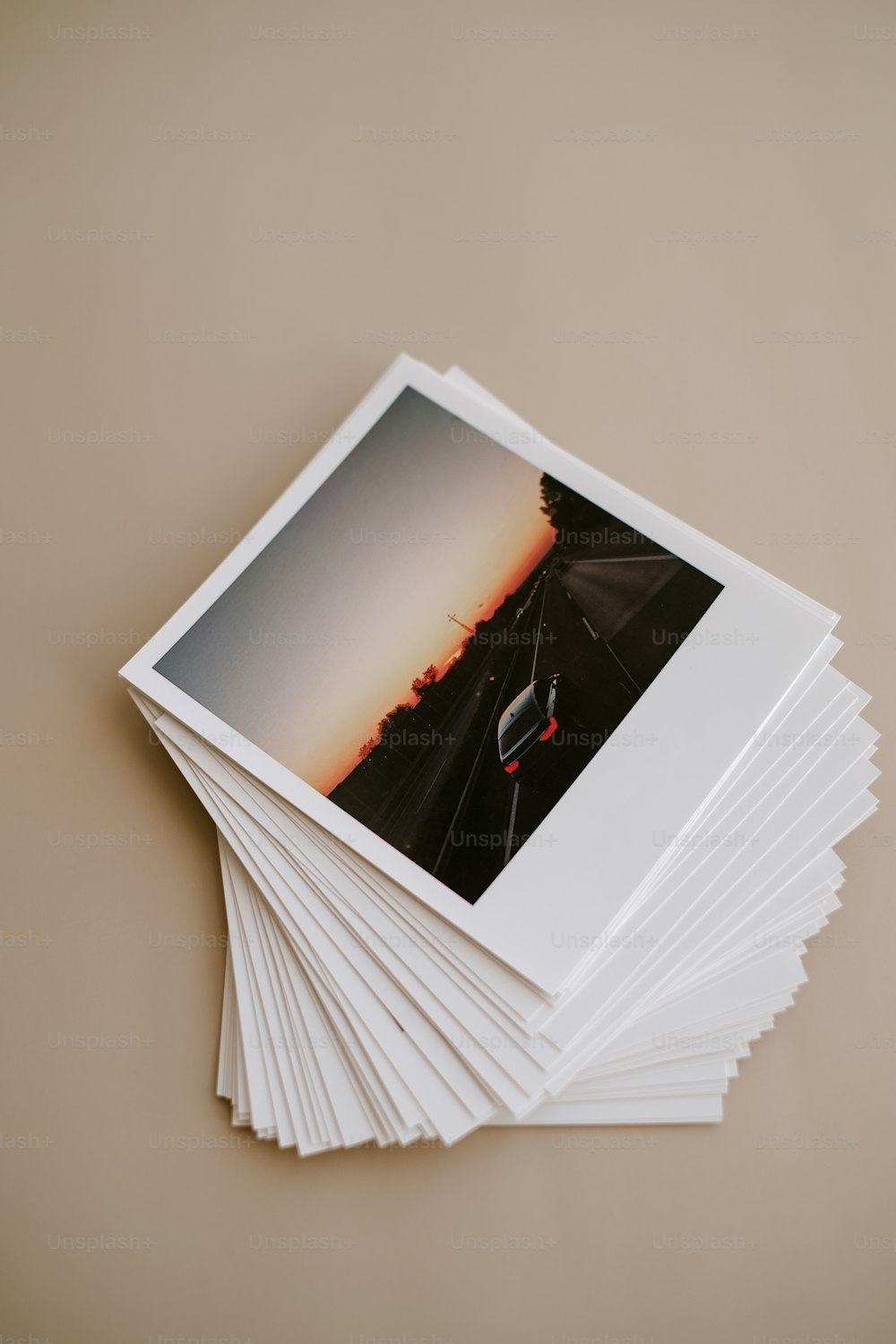 uma pilha de fotos polaroid sentada em cima de uma mesa