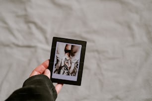 uma pessoa segurando uma pequena foto de uma mulher