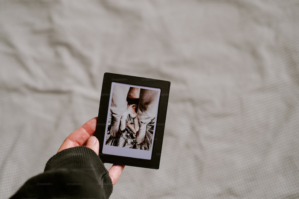 a person holding a small picture of a woman