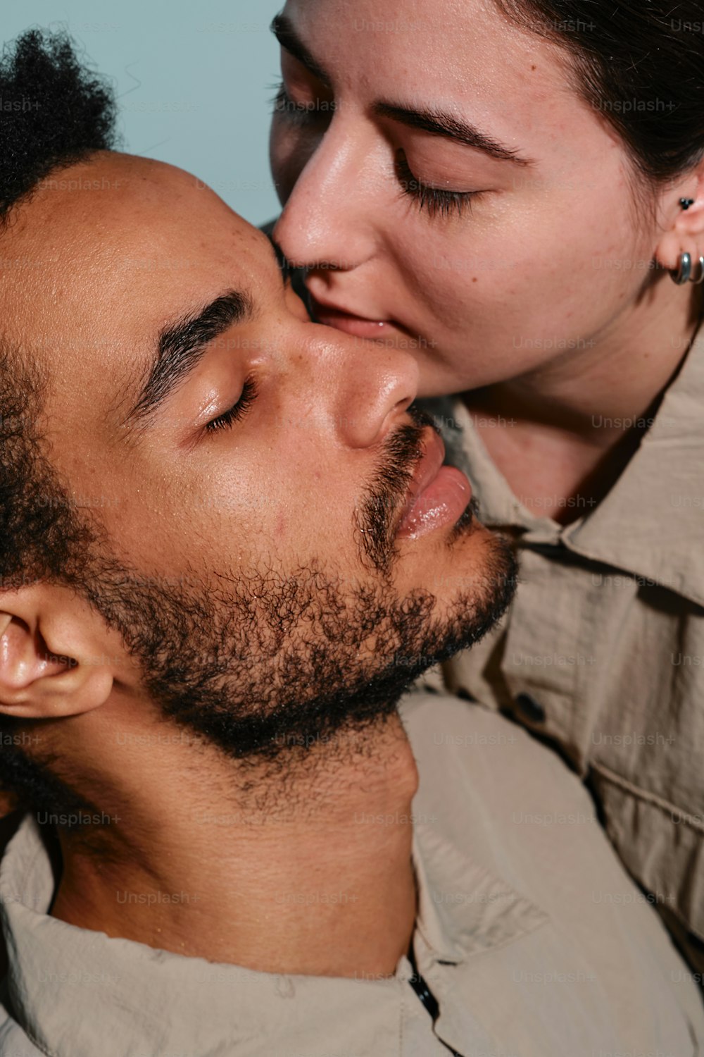 um homem beijando o rosto de uma mulher com um sorriso no rosto
