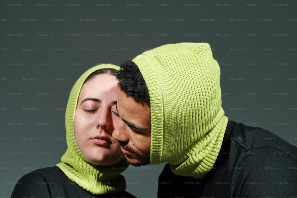 um homem e uma mulher usando um chapéu verde