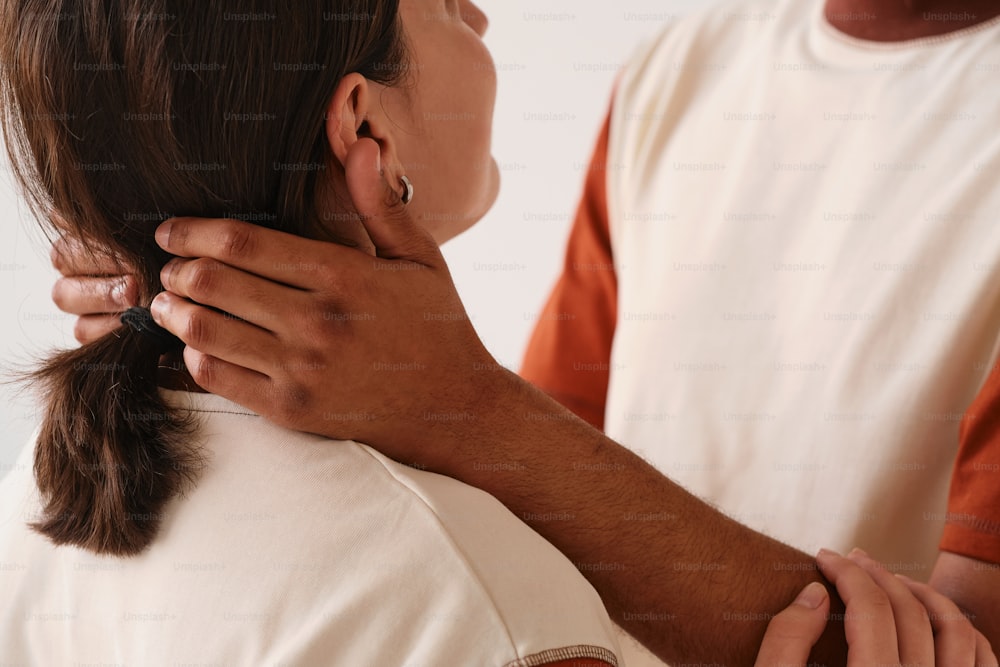 a woman is holding the back of a man's neck