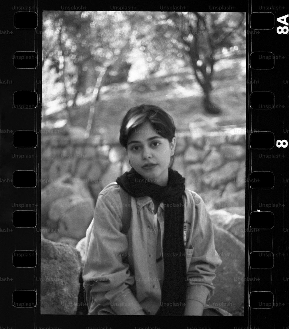 a black and white photo of a woman with a scarf around her neck