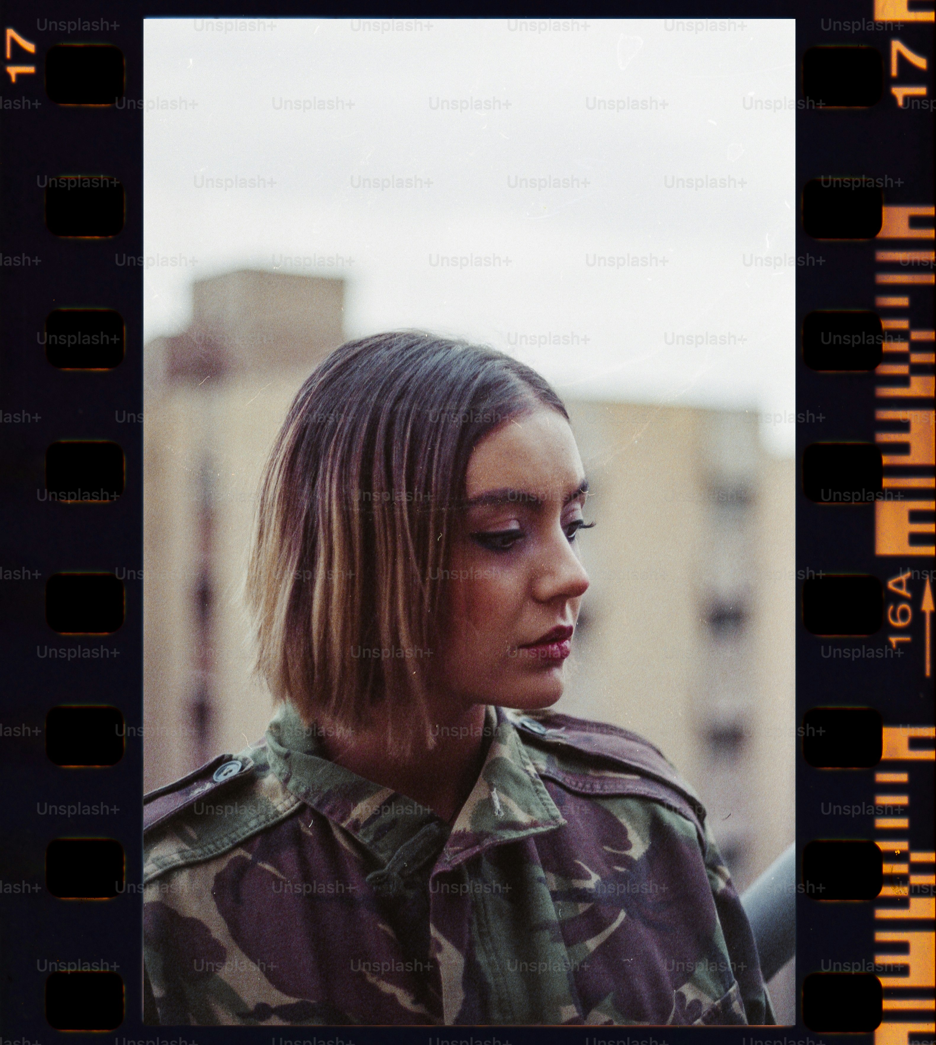 a woman in a camo shirt looking at her cell phone