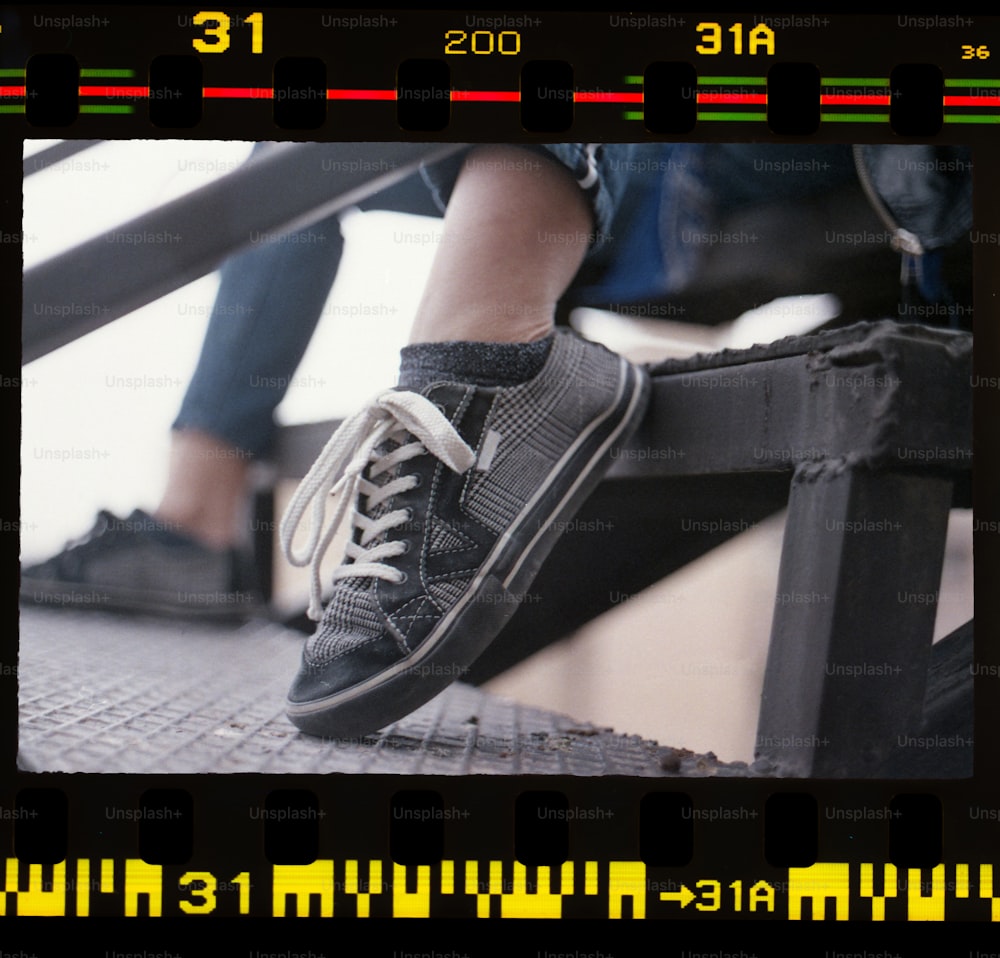 uma imagem dos pés de uma pessoa em um corrimão de metal