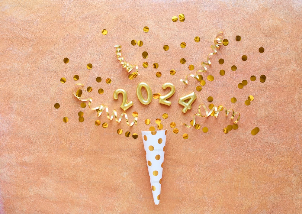 a white cone with gold confetti on top of it