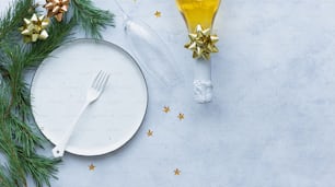 Un plato blanco con tenedor y cuchillo junto a una botella de aceite de oliva