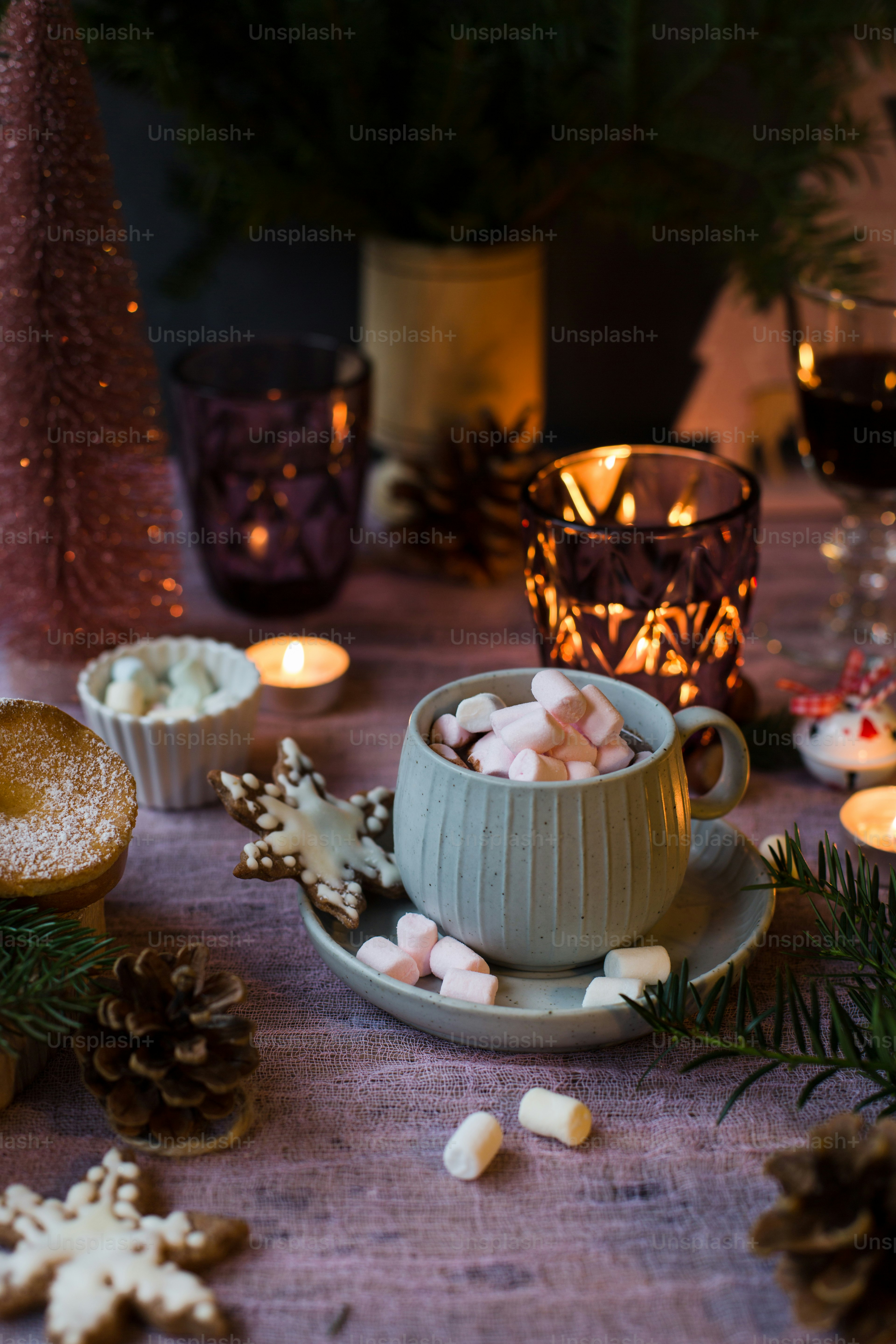 a table topped with a cup filled with marshmallows