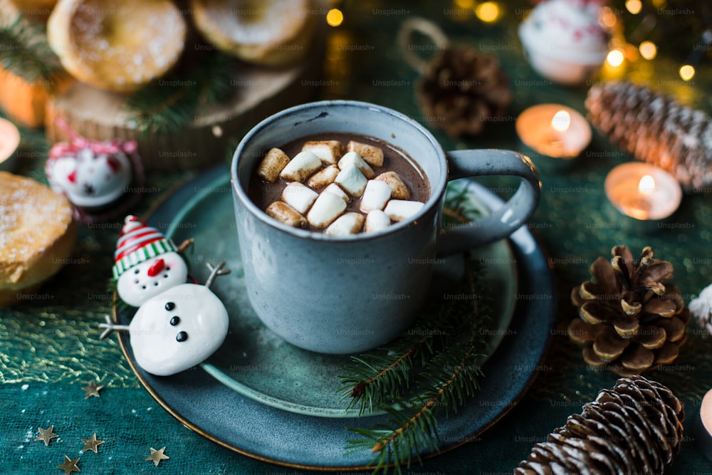 a cup of hot chocolate with marshmallows on a plate