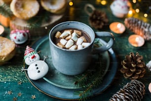 a cup of hot chocolate with marshmallows on a plate