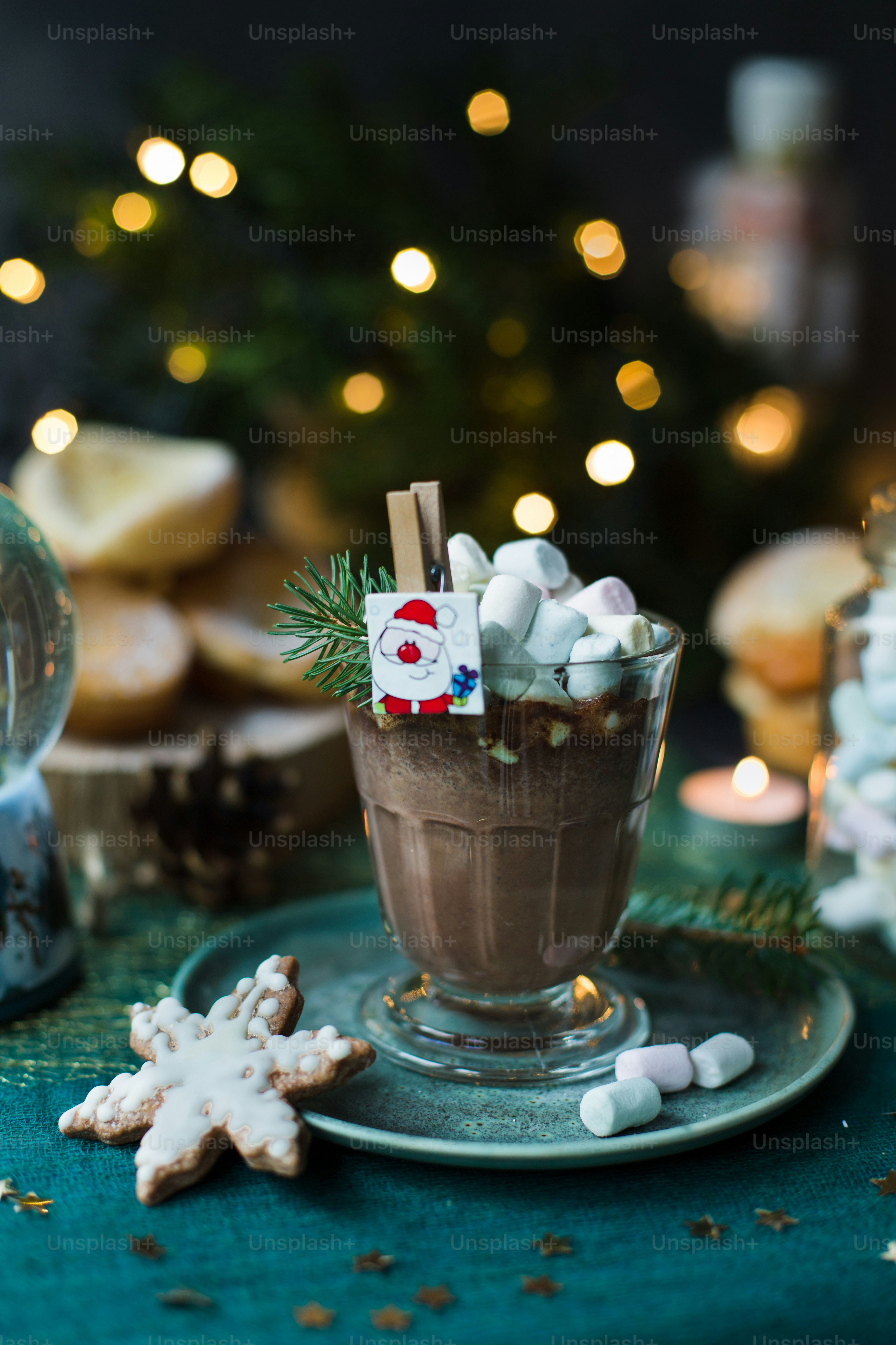a cup of hot chocolate with marshmallows on a plate