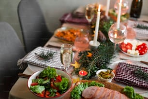 uma mesa com uma tigela de salada e pratos de comida