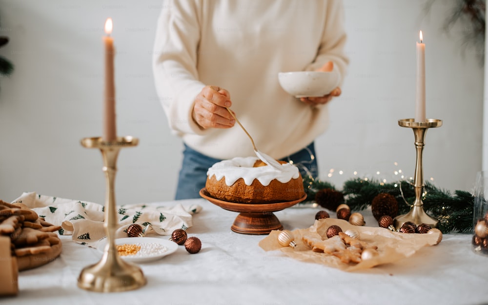 eine Person, die vor einem Tisch steht, auf dem ein Kuchen steht