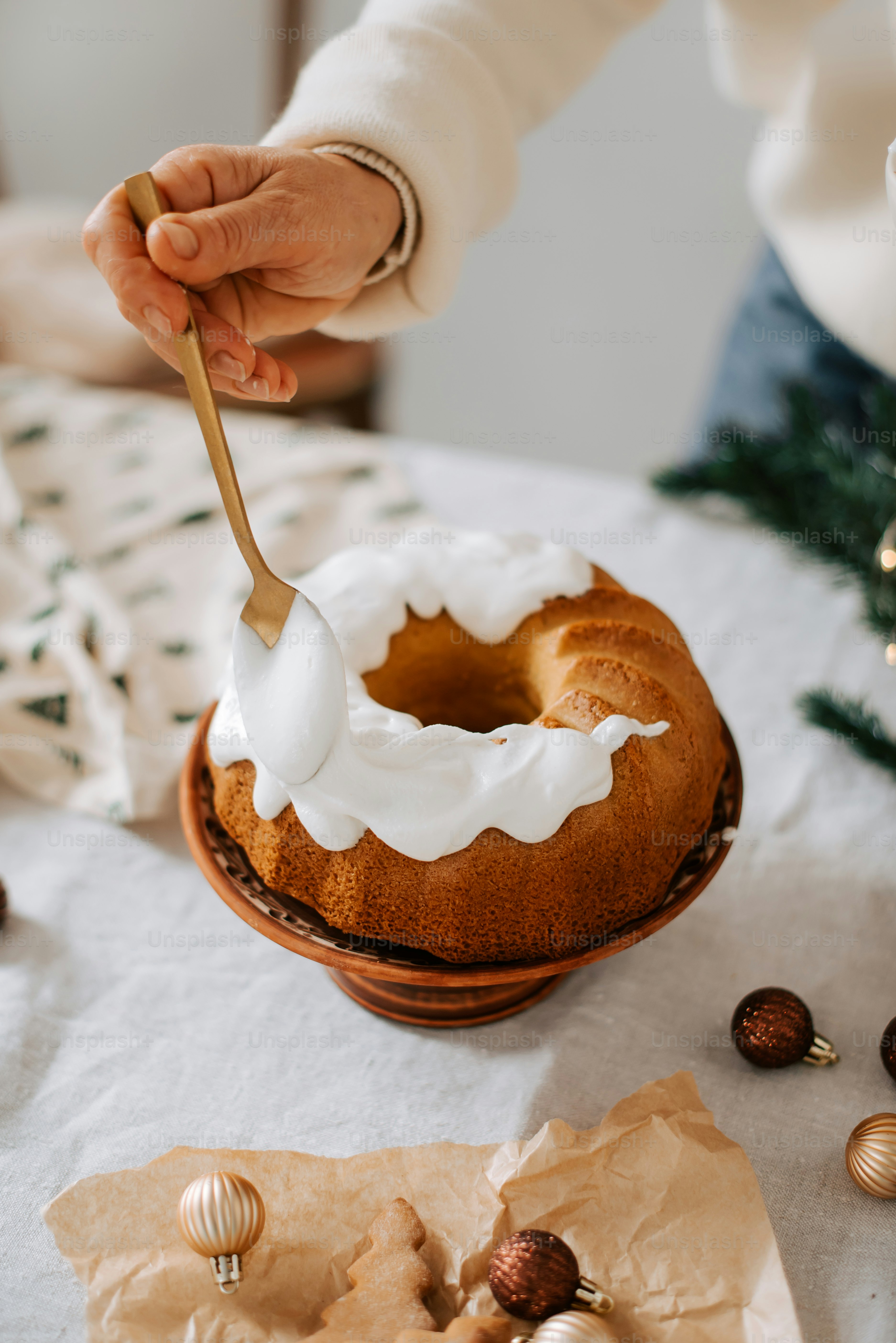 a person is spreading icing on a bundt cake