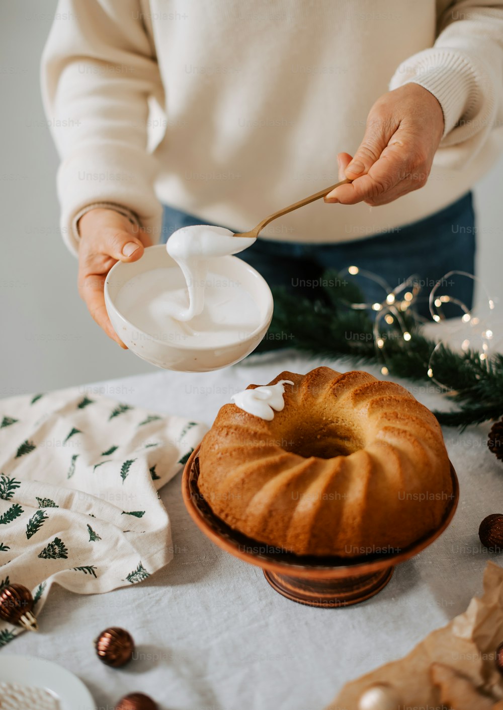 a person pouring sugar on a bundt cake