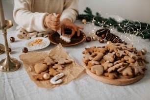 uma pessoa está decorando biscoitos em uma mesa