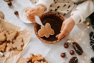 a person is decorating some cookies in a bowl