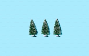 Três pequenas árvores de Natal em um fundo azul