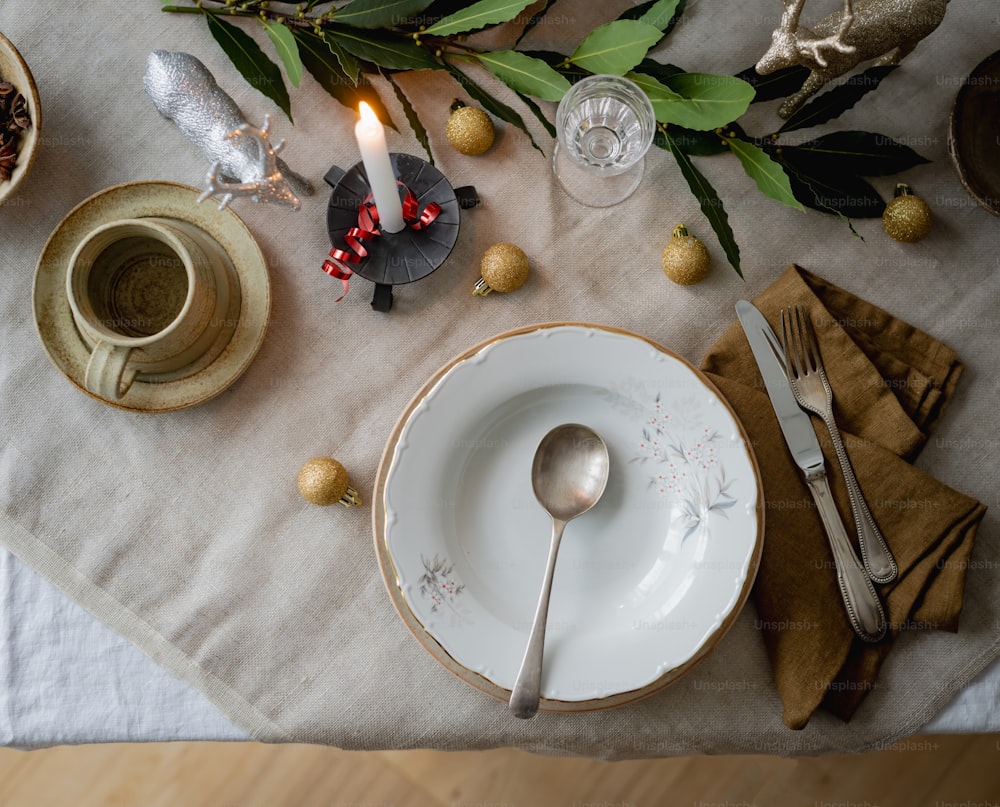 una mesa con un plato blanco y cubiertos