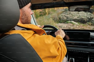 a man in a yellow jacket driving a car