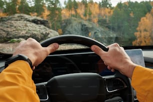 un homme conduisant une voiture avec les mains sur le volant