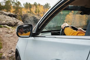 a man driving a car on a dirt road