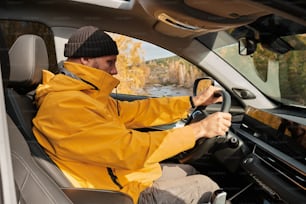 a man in a yellow jacket driving a car