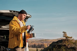 a man in a yellow jacket holding a coffee mug