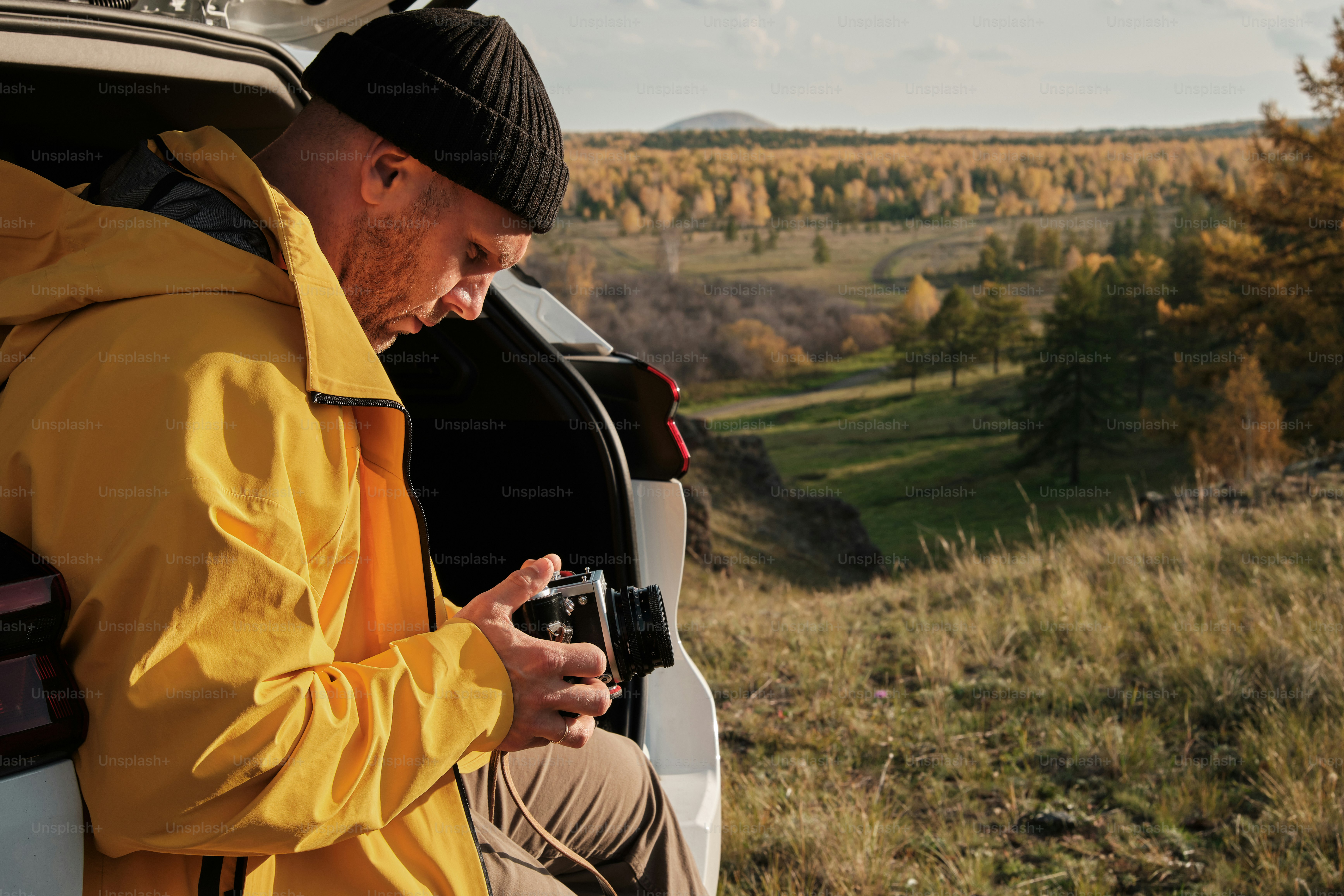 Un homme assis à l’arrière d’un camion regarde son téléphone portable