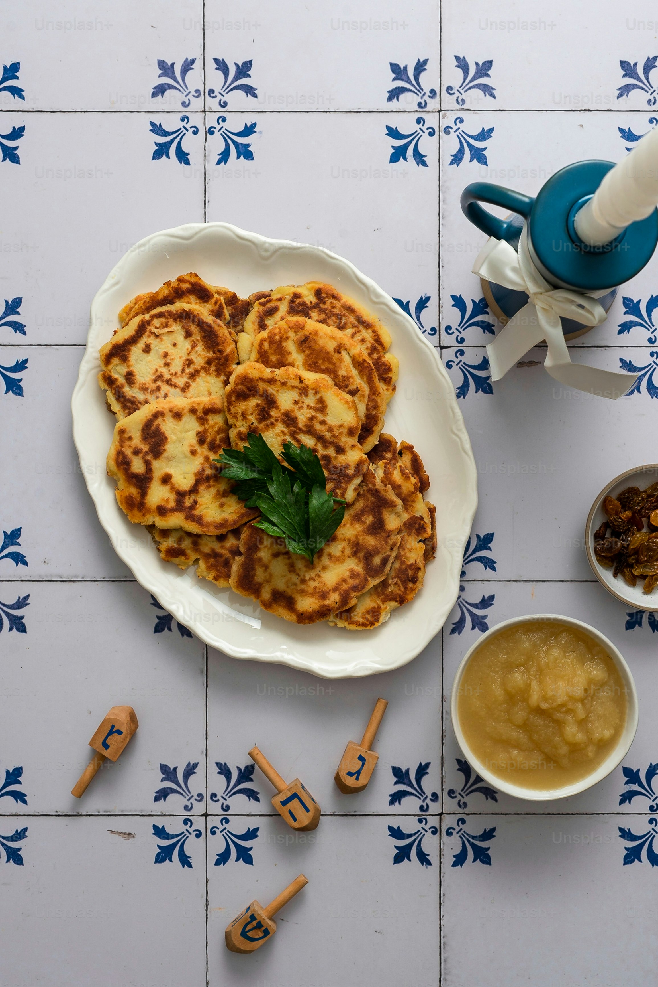 a white plate topped with pancakes next to a bowl of peanut butter