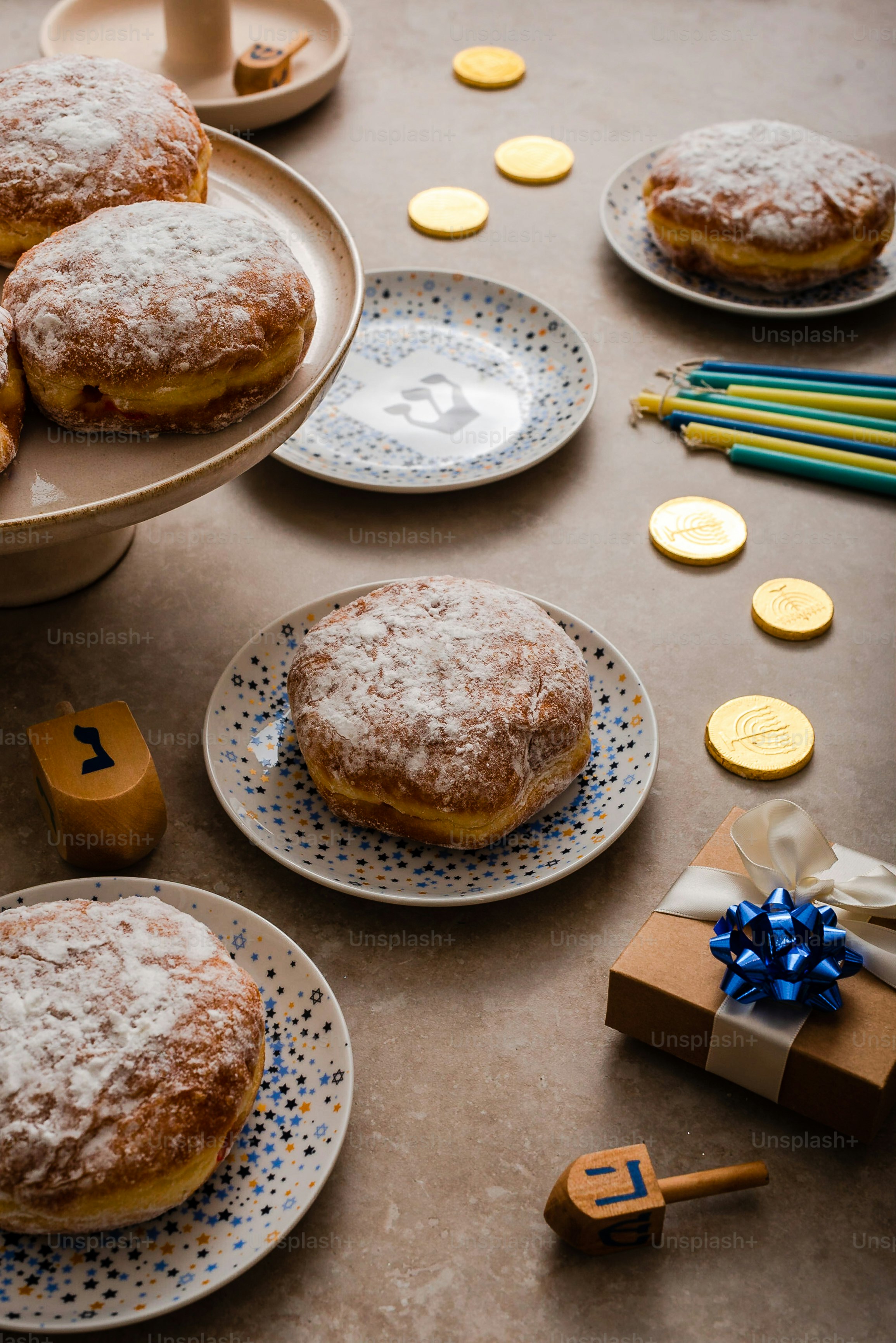 a table topped with plates of donuts covered in powdered sugar