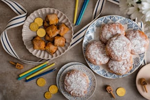 a table topped with plates of powdered sugar covered donuts