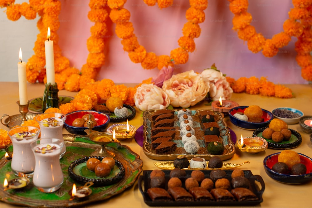 a table topped with plates of food and candles