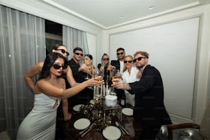 a group of people standing around a table with drinks