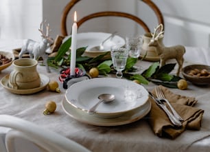 a table set for a holiday dinner with a candle