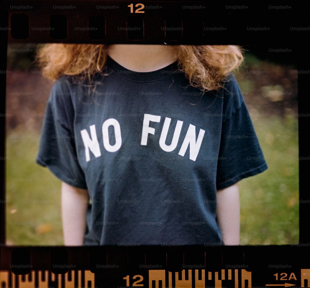 a girl with red hair wearing a black t - shirt that says no fun