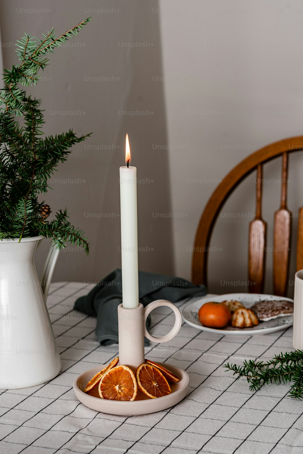 a candle is lit on a plate with orange slices