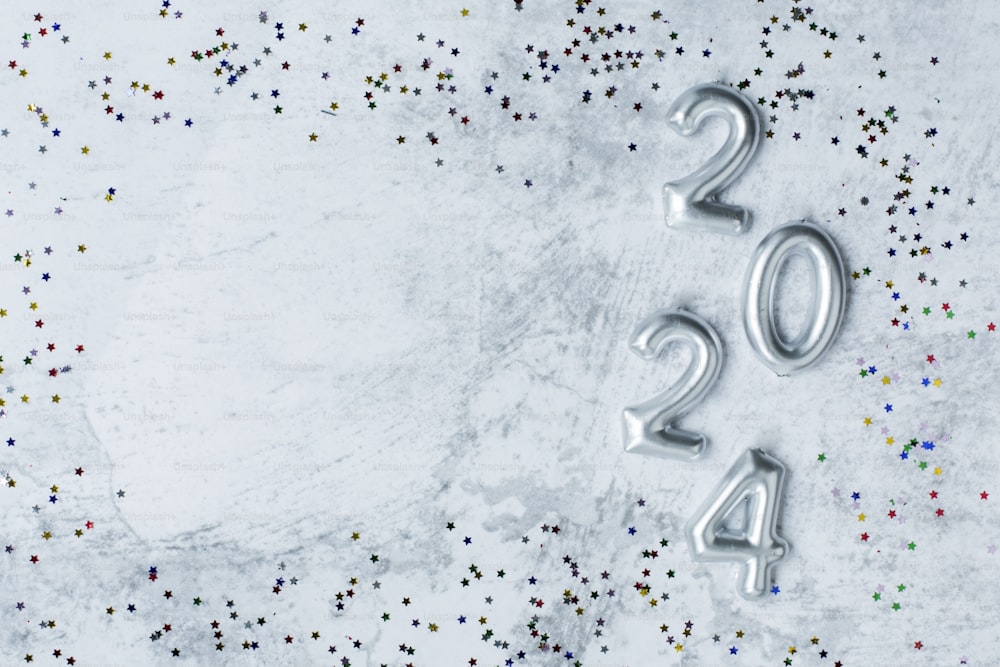 a white table topped with silver numbers and confetti