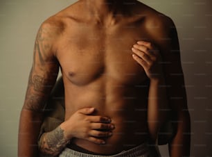 a man with a tattooed arm holding his chest