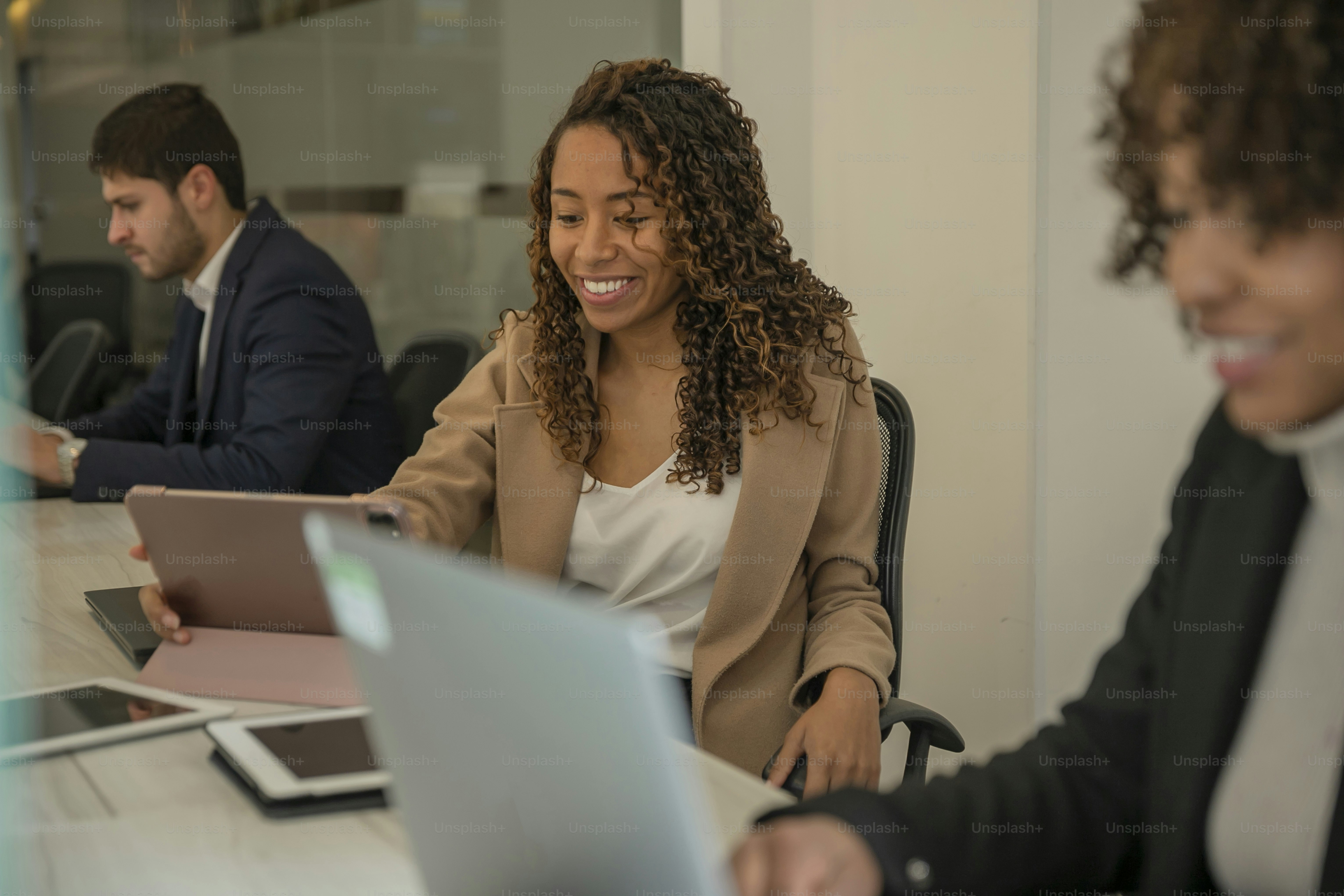 un groupe de personnes assises autour d’une table avec des ordinateurs portables