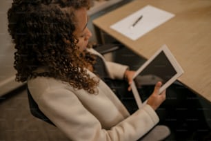 una mujer sentada en un escritorio con una tableta