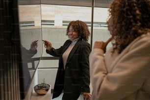 a woman standing in front of a mirror holding a cell phone
