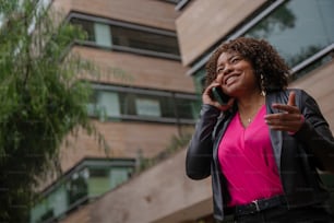 une femme parlant au téléphone portable devant un immeuble