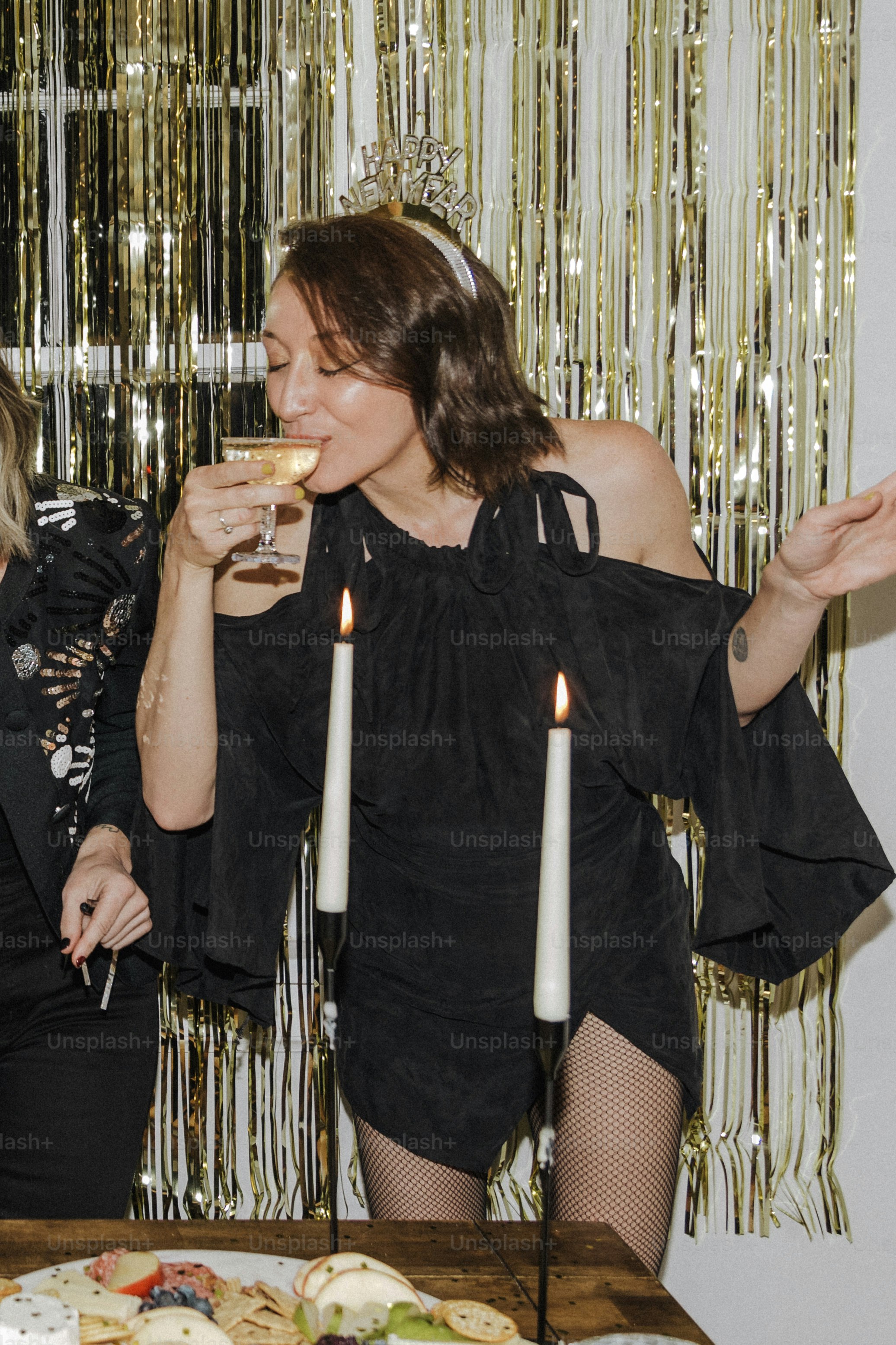 a couple of women standing next to each other in front of a cake